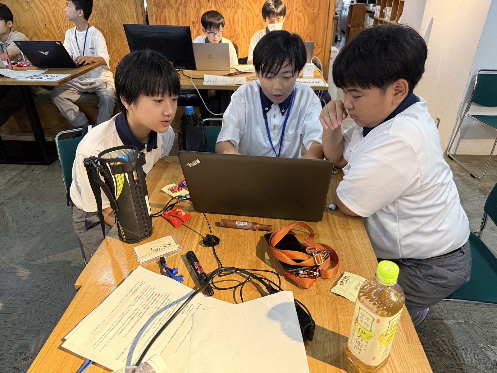 1台のノートPCを囲んで開発する3人のようす